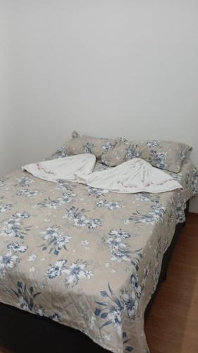 a bed with a blue and white blanket on it at Apartamento Cabedelo João Pessoa in Cabedelo