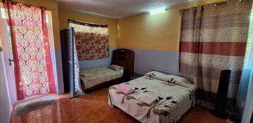 a small room with two beds and curtains at Chez Caze Maman in Crève Coeur