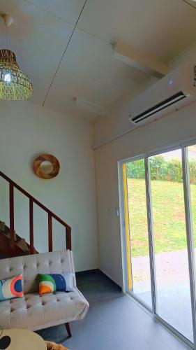 un soggiorno con un divano e una porta scorrevole in vetro di Emma modern suite a Kourou