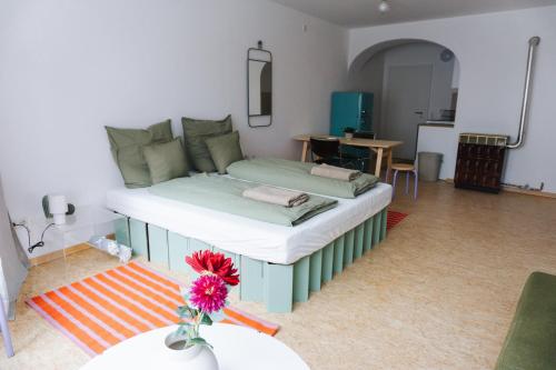 a bed in a living room with a table at raum life - Design Apartment mit Küche in der Altstadt in Regensburg