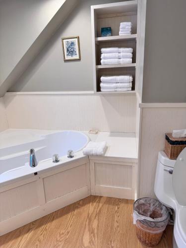 a white bathroom with a tub and a toilet at The Landgrove in North Landgrove