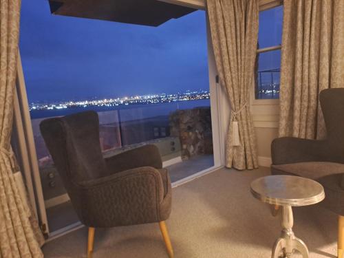a room with a large window with a view at Boutique Inn - Azure in Gordonʼs Bay