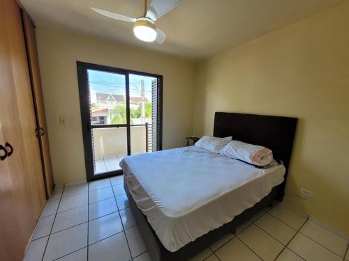 a bedroom with a bed and a large window at Lar no Atami com piscina aquecida in Pontal do Paraná