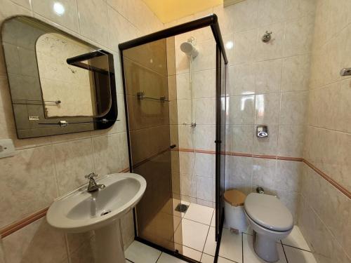 a bathroom with a sink and a shower and a toilet at Lar no Atami com piscina aquecida in Pontal do Paraná