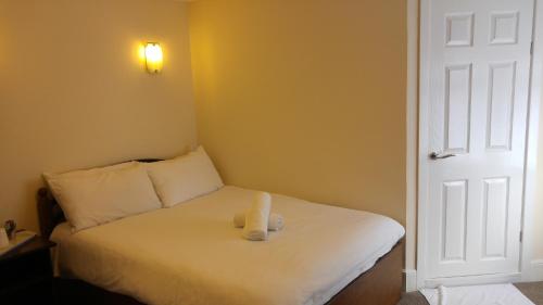 a teddy bear sitting on a bed in a room at City View Hotel Stratford in London