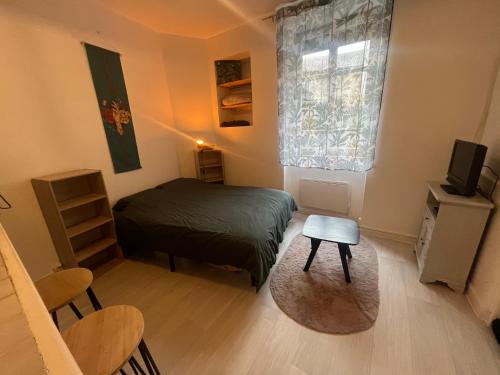 a small bedroom with a bed and a window at Studio meublé centre-ville Saint Junien in Saint-Junien