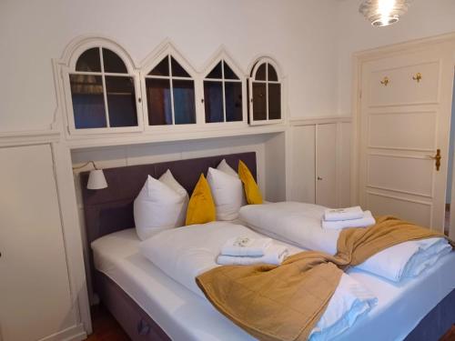 a bedroom with two beds with white and yellow pillows at Ferienwohnung 'Bergidylle' - Zu Fuß auf die Loipe und den Berg, nur wenige Minuten ins Skigebiet in Bayrischzell