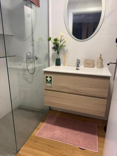 a bathroom with a sink and a mirror at Cozy House in Funchal