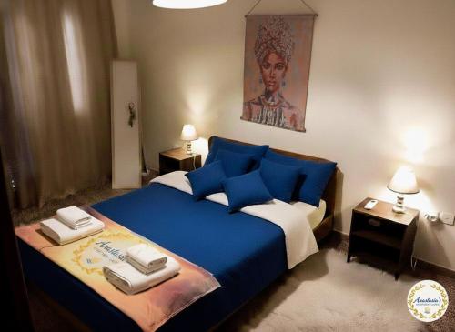 a bedroom with a blue bed with towels on it at Anastasia's Apartment ΛΑΥΡΙΟ in Lavrio