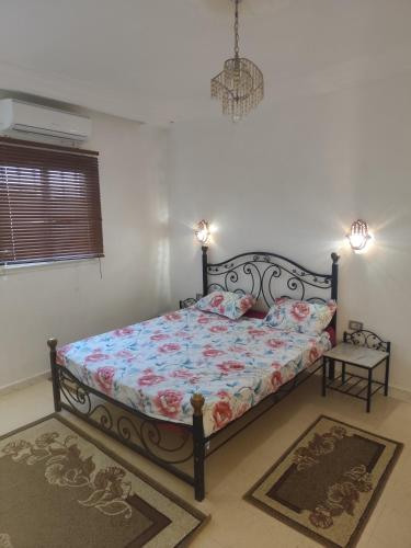 a bedroom with a bed with a floral comforter at Dar Karim in Midoun