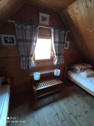 a small attic room with two beds and a window at Chalet Le Gentiane in Bun