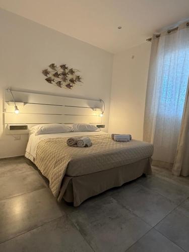a bedroom with a bed with two towels on it at Arneo Rooms in Torre Lapillo