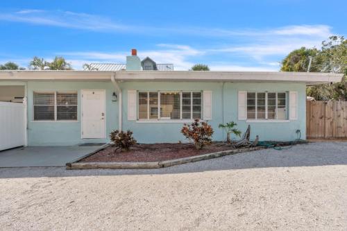 a blue house with a fence in front of it at Island Gem B home in Anna Maria