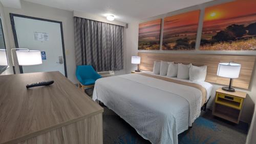 a hotel room with a bed and a desk at Days Inn by Wyndham Champaign/Urbana in Champaign