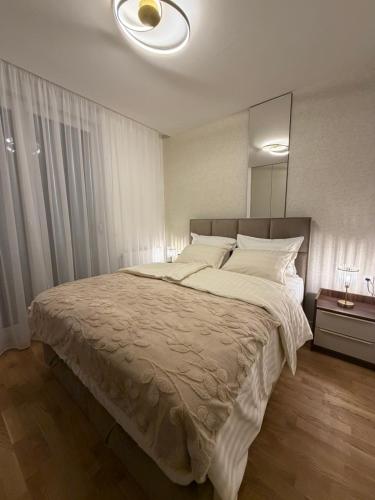 a bedroom with a large bed with a large mirror at Stelmar Apartment in Banja Luka