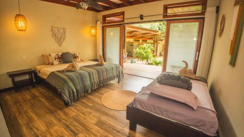 una camera da letto con due letti, un divano e una finestra di Playa Bluff Lodge a Bocas del Toro