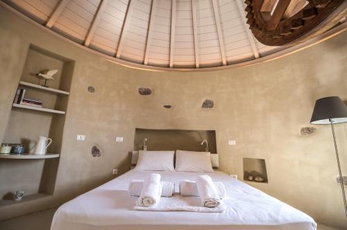 a bedroom with a bed with towels on it at Traditional Windmill House , Chora Serifos in Serifos Chora