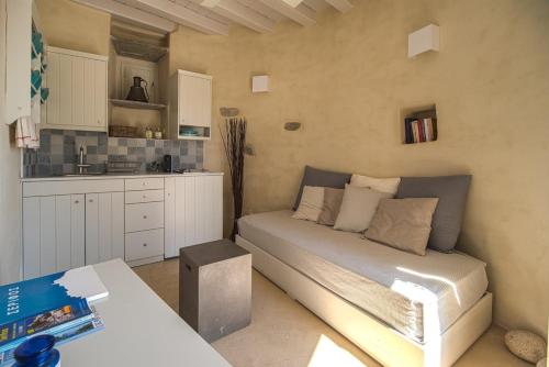 a small room with a bed and a kitchen at Traditional Windmill House , Chora Serifos in Serifos Chora
