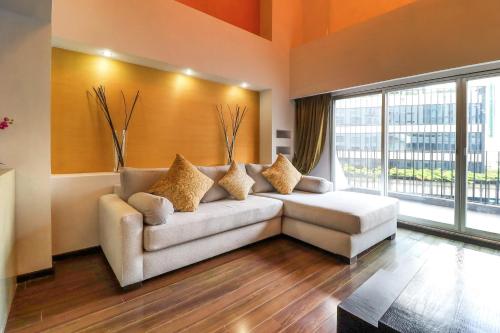 a living room with a couch and a large window at St Isidro Suites Corporate Housing SPA & Wellness Center in Mexico City