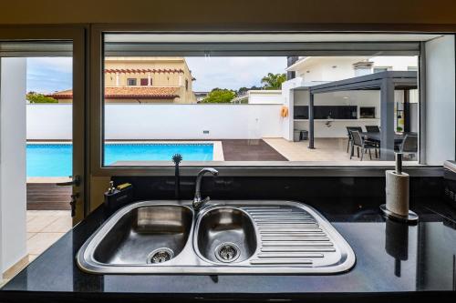 a kitchen sink with a view of a pool at Nazare House4you in Nazaré