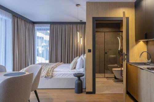 a hotel room with a bed and a bathroom at Apart M in Krynica Zdrój