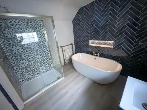 a bathroom with a shower and a bath tub and a sink at The Haven in Banbridge