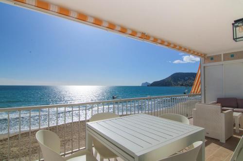 a balcony with a table and chairs and the ocean at Wohnung Rio in Calpe