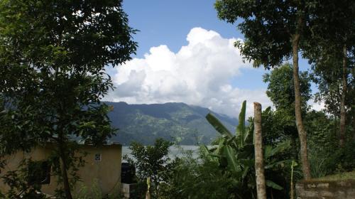 a view of a mountain in the distance with trees at Peace Guest House in Pokhara