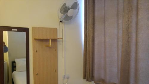 a bedroom with a fan on the wall next to a mirror at City View Hotel Stratford in London