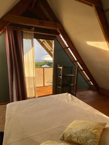 an attic room with a bed and a window at Hare Sunset Rapa Nui in Hanga Roa