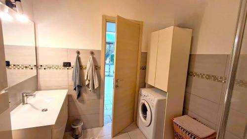 a bathroom with a sink and a washing machine at La Casa di Anastasya in Castiglione Torinese