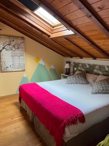 a bedroom with a large bed with a red blanket at Alojamiento Bernabales in Pámanes