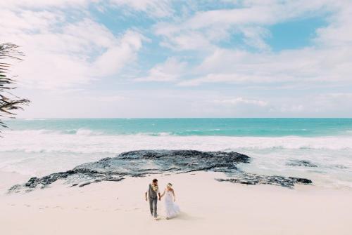 a bride and groom walking on the beach at Yasawa Island Resort & Spa in Mbukama