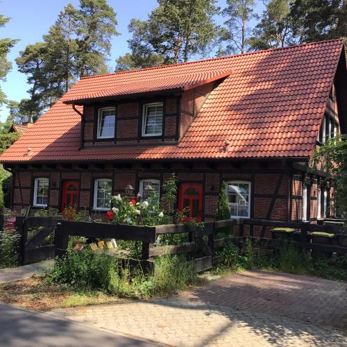 a house with an orange roof and a fence at Welsh Dragon in Siedlung Schönwalde