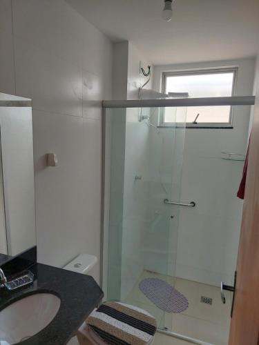 ein Badezimmer mit Glasdusche und Waschbecken in der Unterkunft Flat da Lua in Viçosa