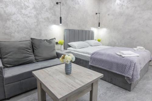 a bedroom with a bed and a couch and a table at Myasnikyan Suites in Gyumri