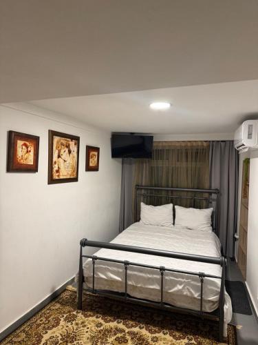 a bedroom with a bed with a television on the wall at Guest house 2 in Amalias