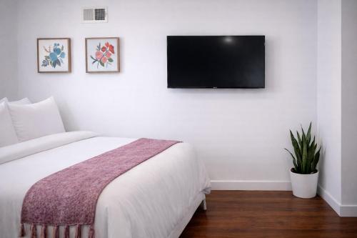 a bedroom with a bed and a flat screen tv on the wall at Artsy Hidden Gem -- FREE PARKING in Philadelphia