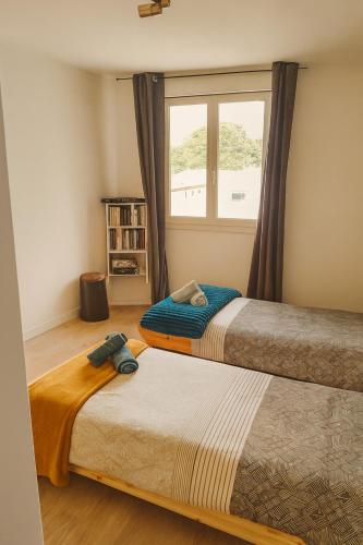 Appartement modulable في لانيميزان: سريران في غرفة بها نافذة