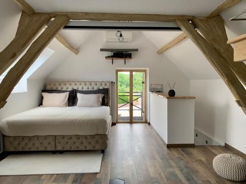 a bedroom with a large bed and wooden beams at Cocon de Fontaine in La Madeleine-de-Nonancourt