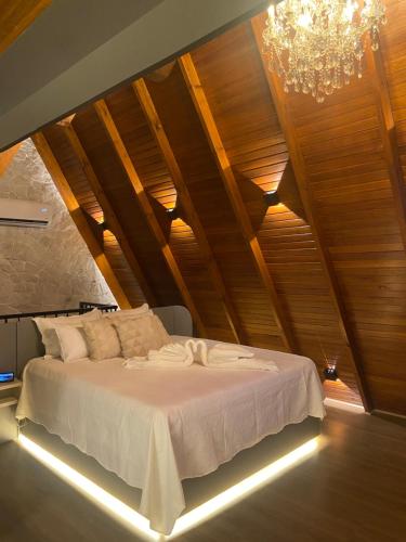 a bedroom with a large bed with a chandelier at Cabana Espelho da Lua in Itá