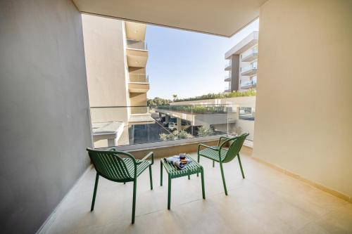 two chairs and a table in a room with a large window at 1 bedroom flat next to university in Aglantzia