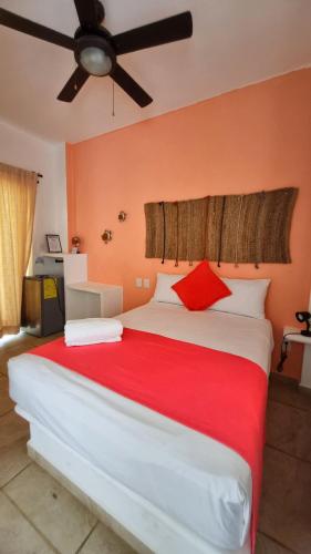 a bedroom with a large white bed with red pillows at blue BOCANA in Santa Cruz Huatulco