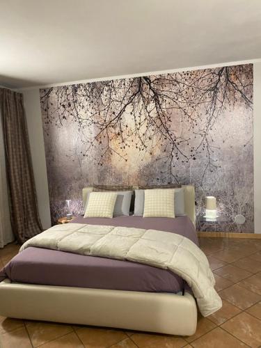a bedroom with a bed with a painting on the wall at Asfodelo rooms in Bra