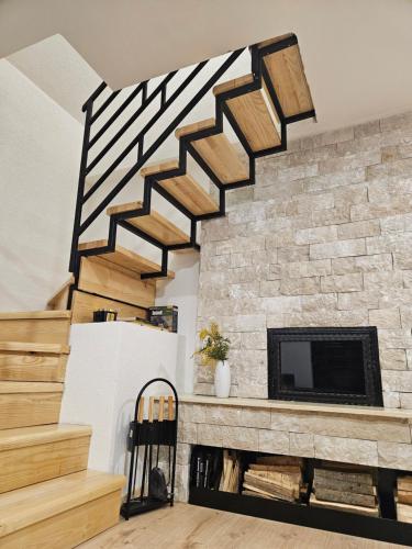 a living room with a stone fireplace and stairs at Vikendica 937 Lux & Spa, Istočno Sarajevo, Pale, Jahorina i Sarajevo na 15km in Pale