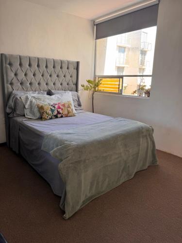 a bedroom with a large bed with a large window at Cómodo departamento in Santa María Coronanco