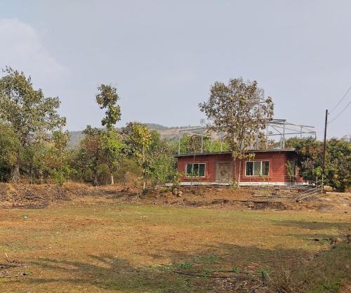 a house sitting on top of a field at Golden Oriole Homestay in Srīvardhan