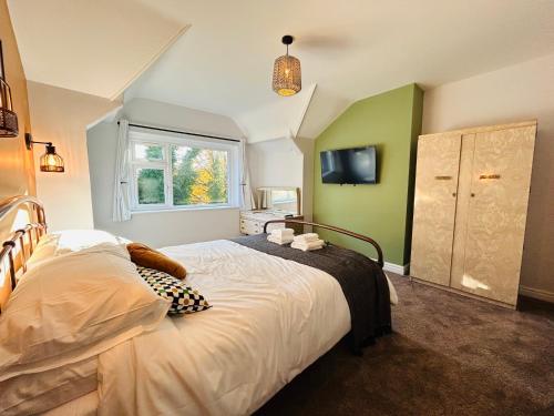 a bedroom with a large bed and a window at Park Mount Residences - Luxury 3 Bedroom Flat In Leeds With Free Parking in Kirkstall