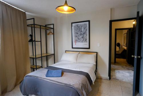 a bedroom with a bed with a blue pillow on it at Comfortable One Bedroom Apartment Casa Icacos # 0 in Mexico City