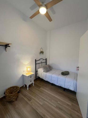 a bedroom with two beds and a table and a ceiling fan at Casa La Culle in Favareta
